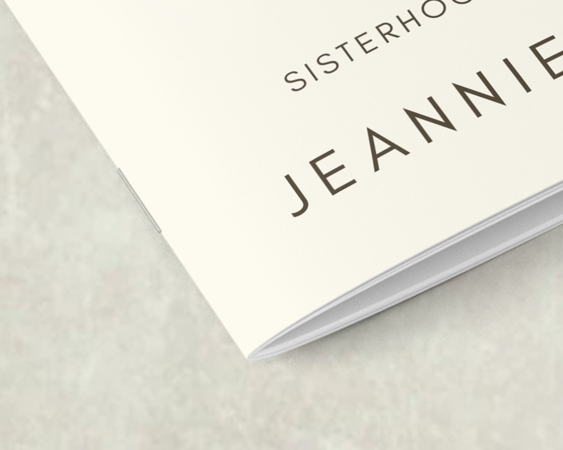 Close-up of a booklet corner showing saddle-stitch binding with two staples along the centerfold.